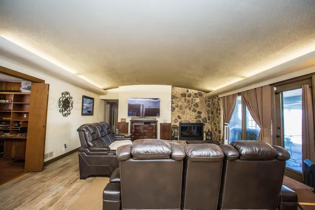 a living room with furniture a flat screen tv and a fireplace