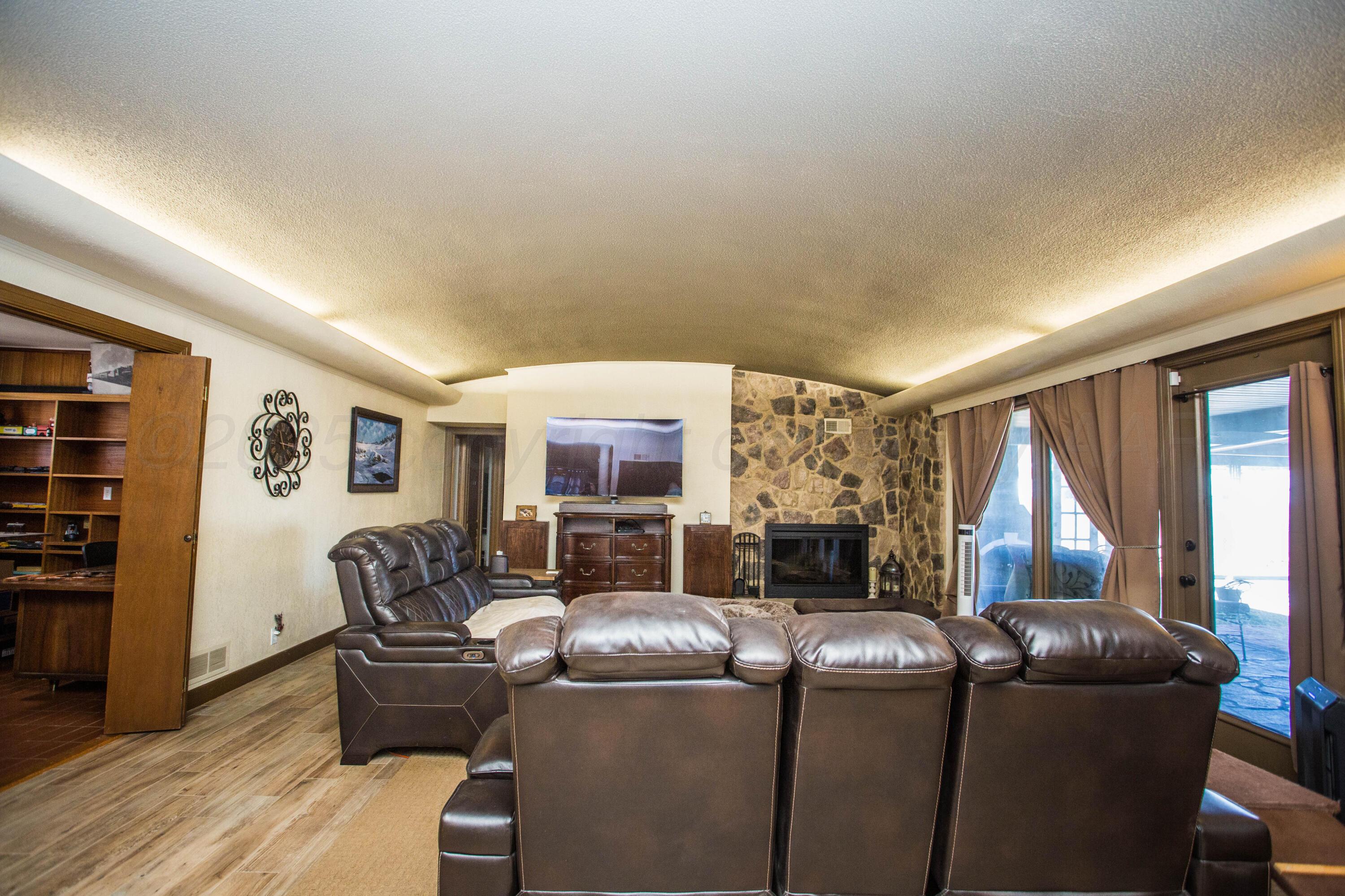 402 Northwest 6th Street Tulia, TX 79088 - Photo 10 of 59 a living room with furniture a flat screen tv and a fireplace