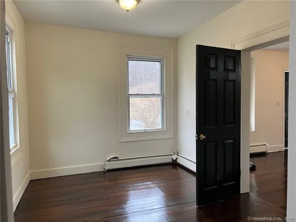 an empty room with wooden floor and closet