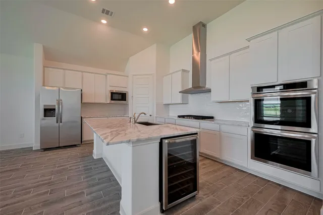 a kitchen with stainless steel appliances granite countertop a stove a sink and a refrigerator