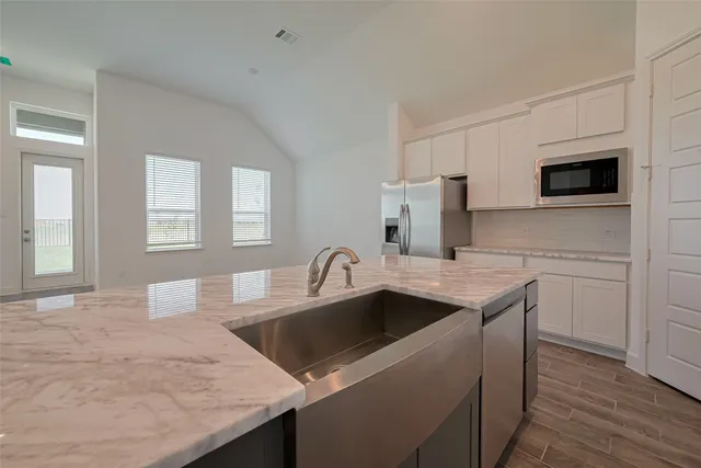 a kitchen with granite countertop a sink and a microwave