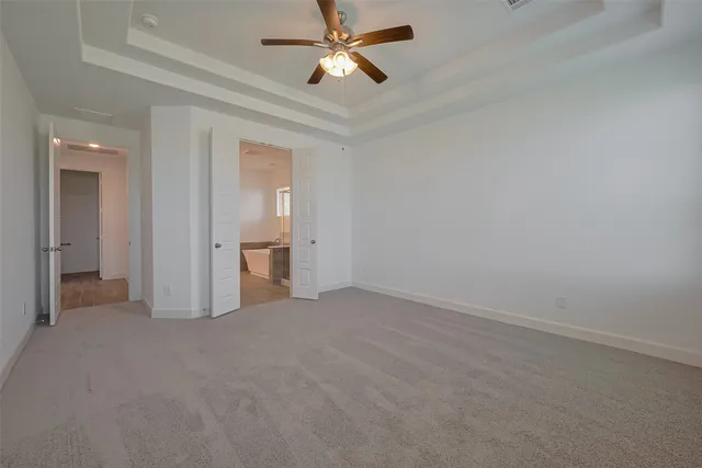 a view of a room with a ceiling fan and a bathroom
