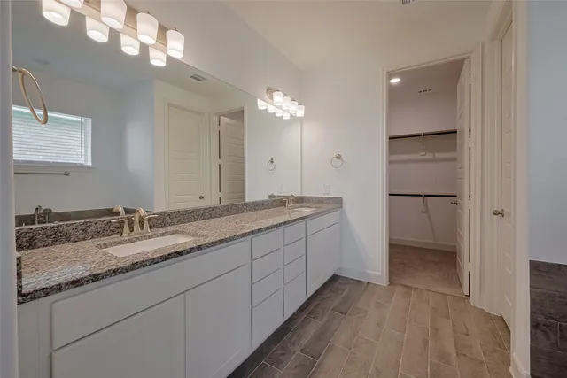 a bathroom with a double vanity sink and a mirror
