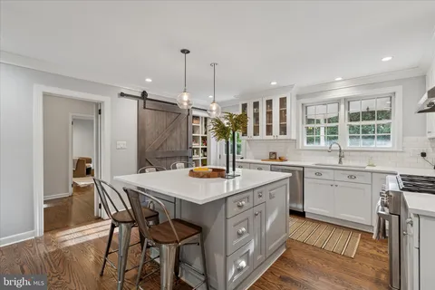 a bathroom with a granite countertop double vanity sink a toilet and a window