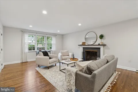 a bathroom with a toilet a sink a mirror and a window