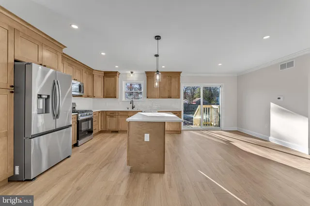 a kitchen with refrigerator a microwave and wooden floor