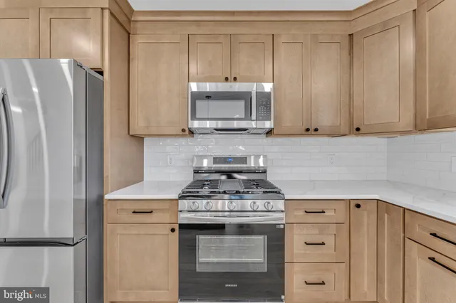 a kitchen with stainless steel appliances white cabinets and a stove top oven