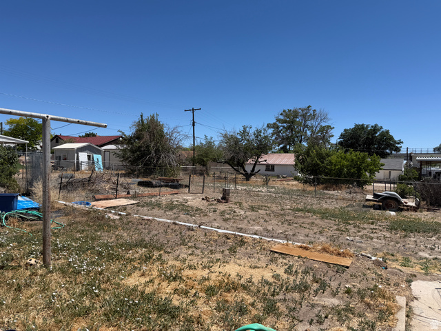 196 North 5th West Price, UT 84501 - Photo 23 of 27 Expansive outdoor space featuring a large clear area, partial concrete slab, and mature trees along the perimeter