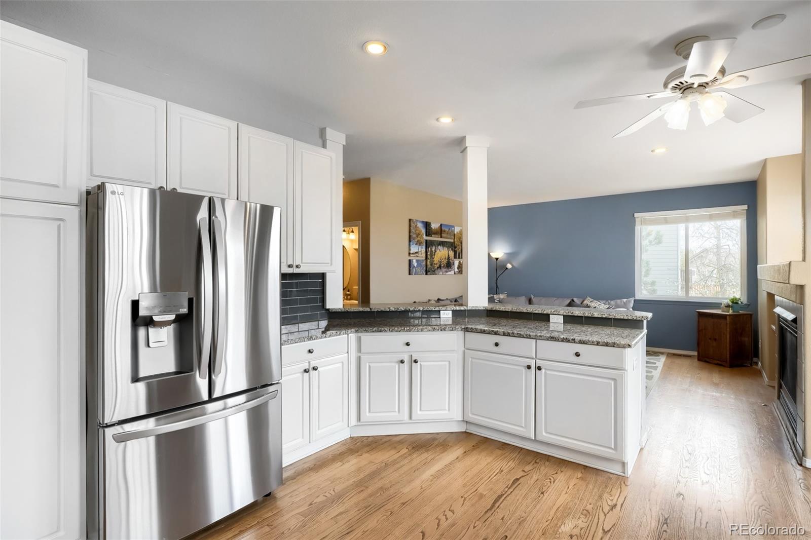 25 Estack Place Highlands Ranch, CO 80126 - Photo 11 of 28 a kitchen with stainless steel appliances a sink cabinets and wooden floor