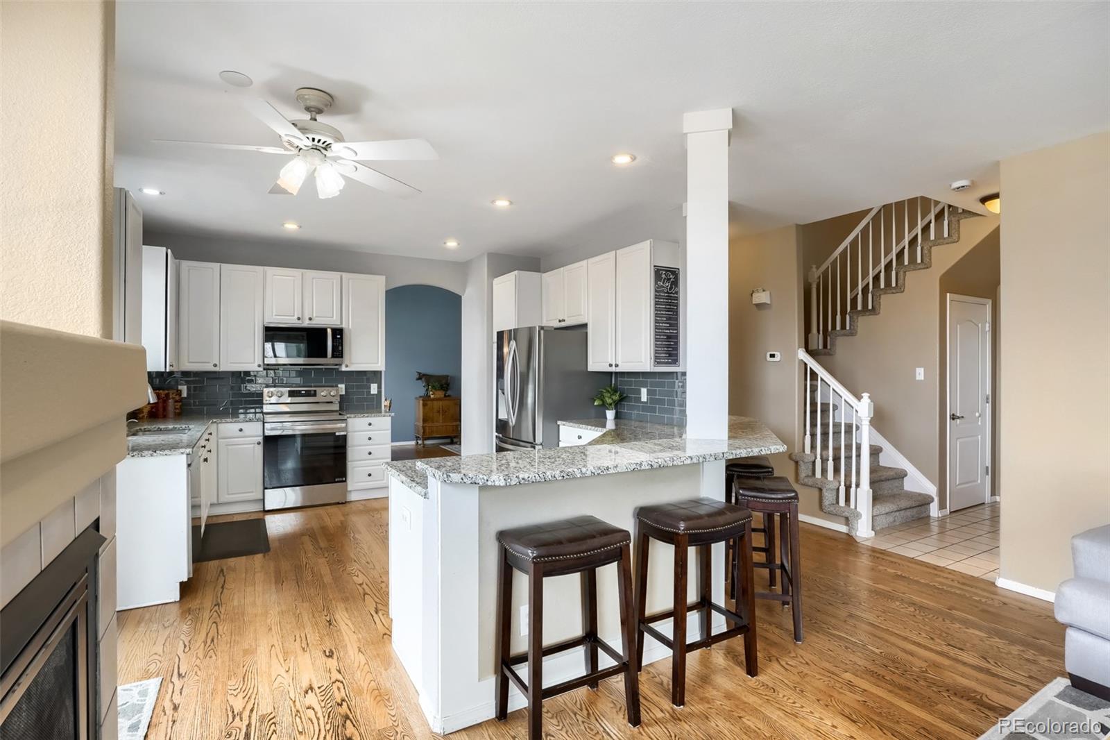 25 Estack Place Highlands Ranch, CO 80126 - Photo 12 of 28 a kitchen with stainless steel appliances kitchen island granite countertop a table chairs and a refrigerator