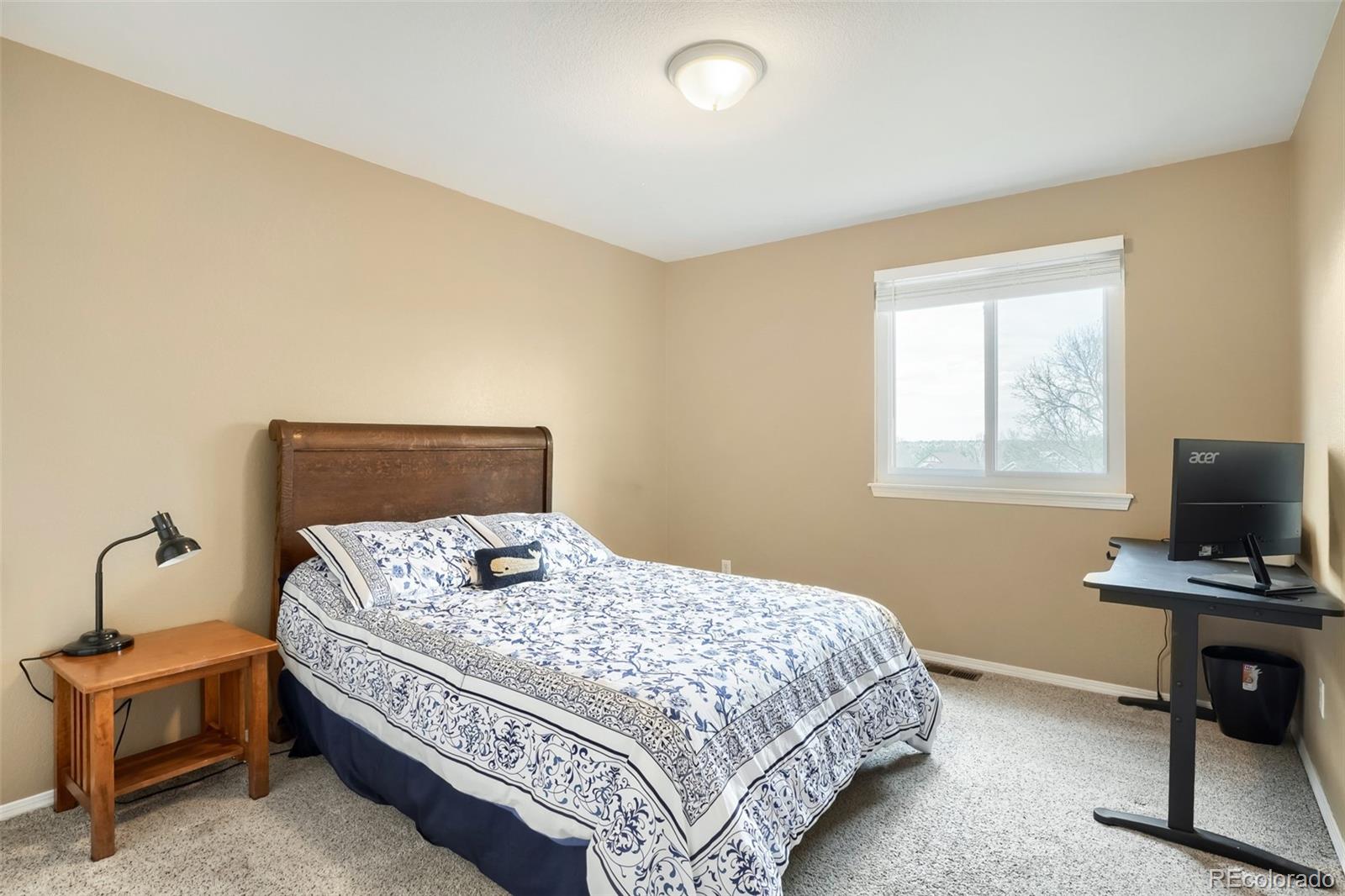 25 Estack Place Highlands Ranch, CO 80126 - Photo 15 of 28 a bedroom with a bed and a tv on the dresser
