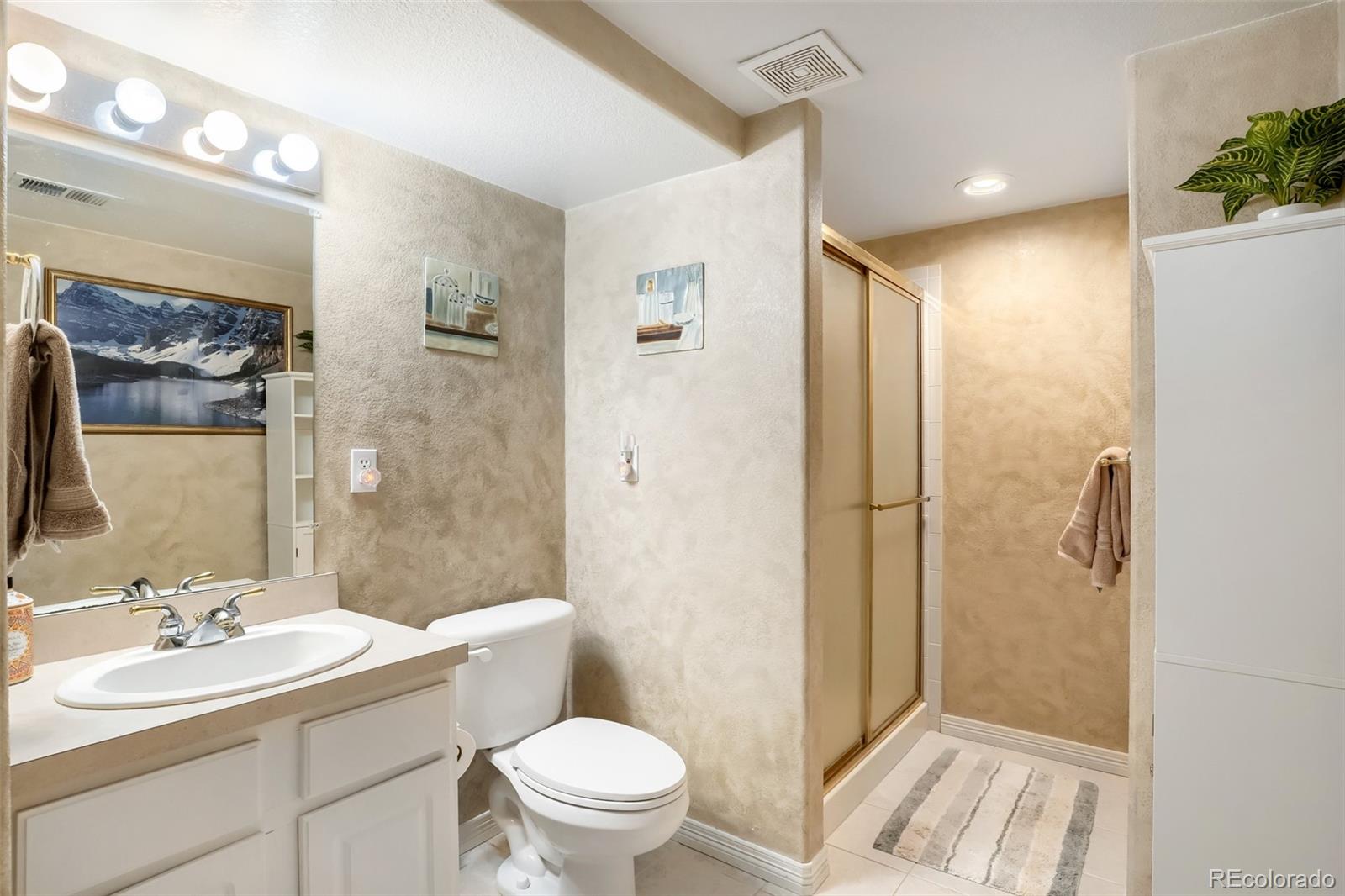 25 Estack Place Highlands Ranch, CO 80126 - Photo 25 of 28 a bathroom with a sink a toilet and shower