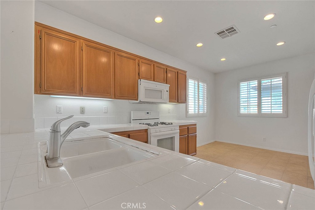 8150 West Preserve Loop Chino, CA 91708 - Photo 19 of 51 a kitchen with a sink stove and cabinets