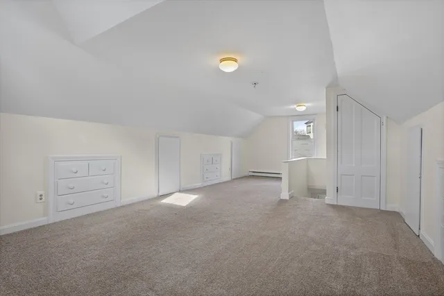 a view of an empty room and chandelier fan