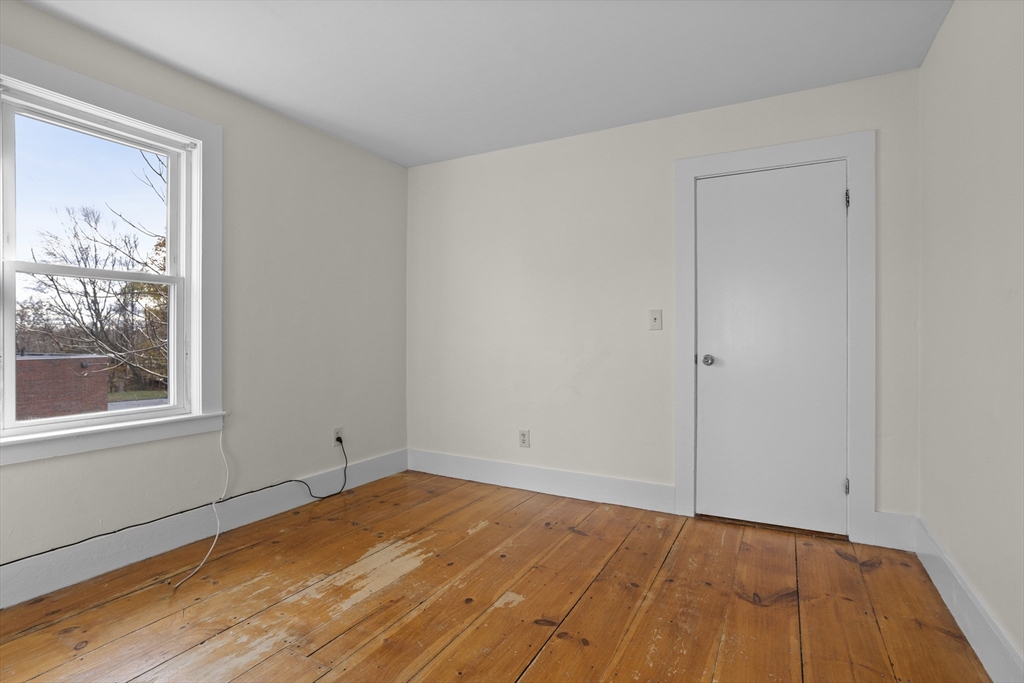 294 Great Road, Unit 2 Littleton, MA 01460 - Photo 7 of 18 a view of empty room with wooden floor and fan