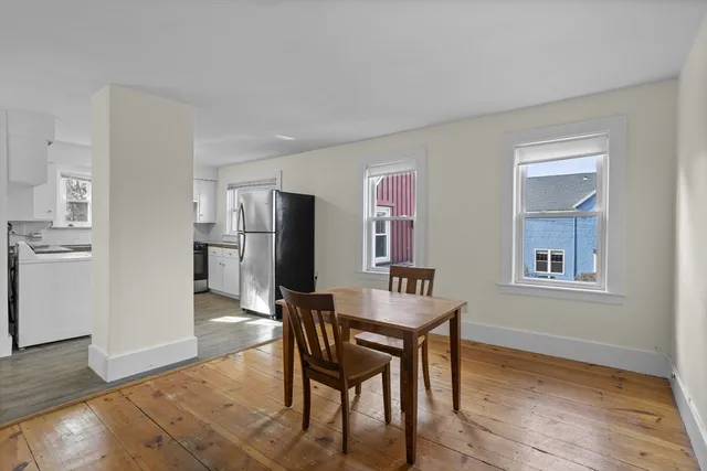 a kitchen with stainless steel appliances refrigerator dining table and chairs
