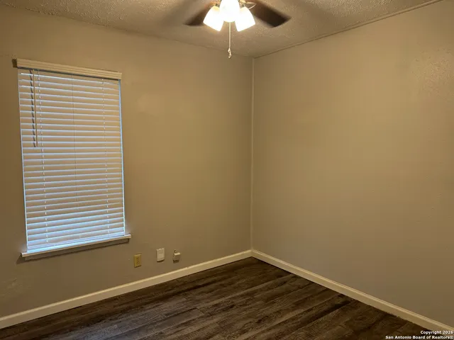 a view of a small space with wooden floor and a window