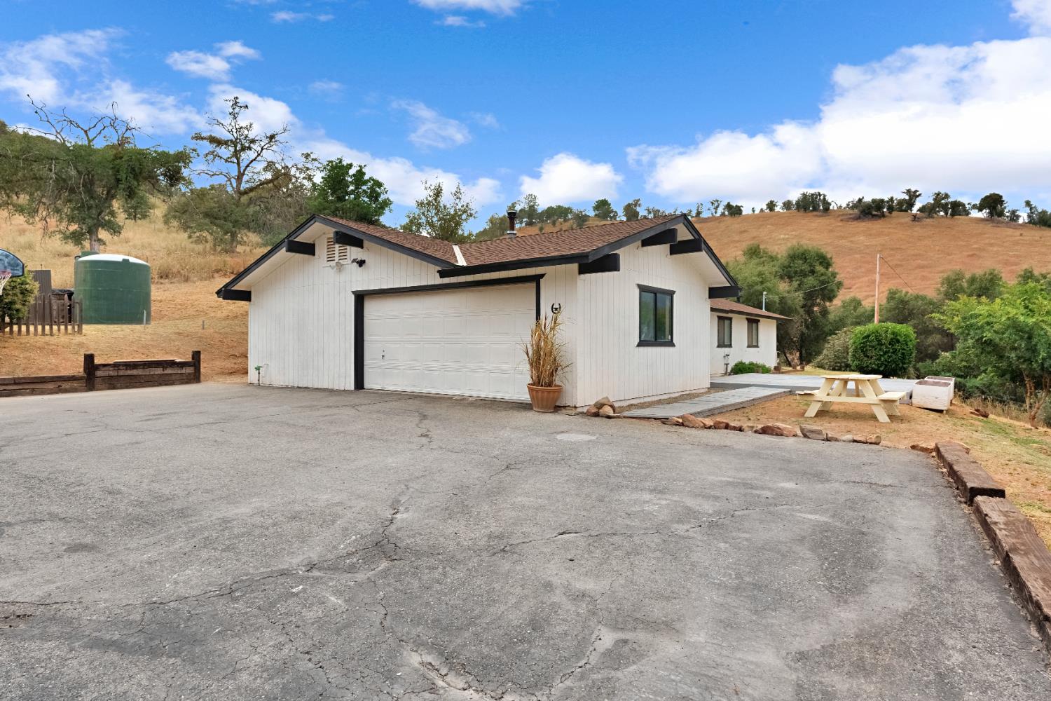29668 Seminole Road Tollhouse, CA 93667 - Photo 21 of 28 a view of a white house with a yard and a garage