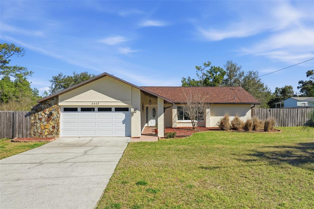 4445 Bayridge Court Spring Hill, FL 34606 - Photo 1 of 1 a front view of a house with a yard and garage
