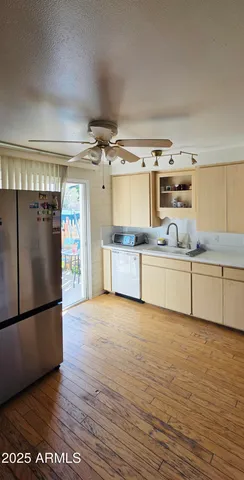 a view of a hallway with wooden floor and a cabinet