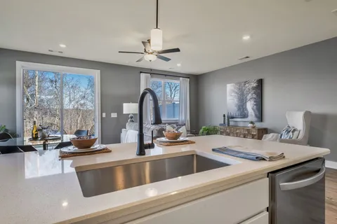 a kitchen with a stove a sink and a chandelier