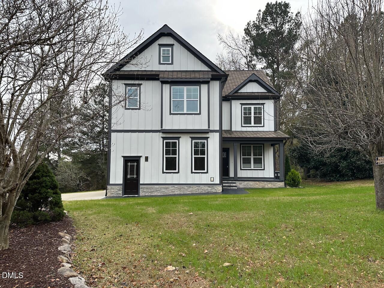 a front view of a house with yard and green space