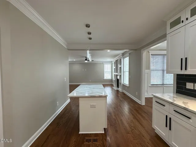 a kitchen with granite countertop a sink cabinets and wooden floor