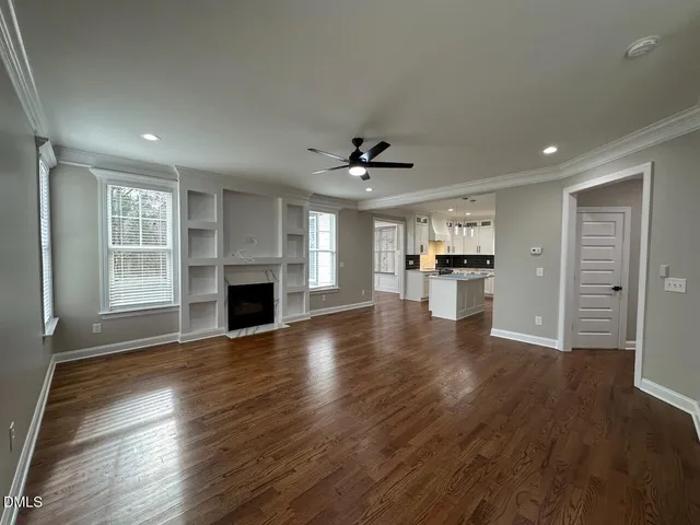 an open space with wooden floor and a kitchen