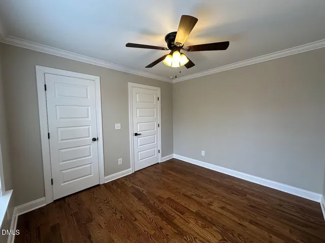 an empty room with closet and fan