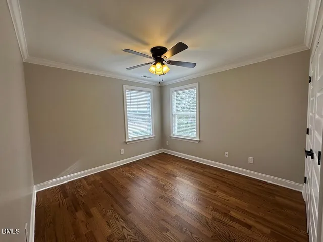 a view of room with window ceiling fan and hardwood floor