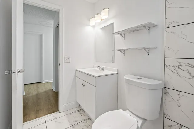 a bathroom with a sink toilet vanity and shower