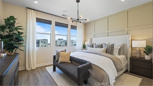 a bedroom with a large bed and a chandelier