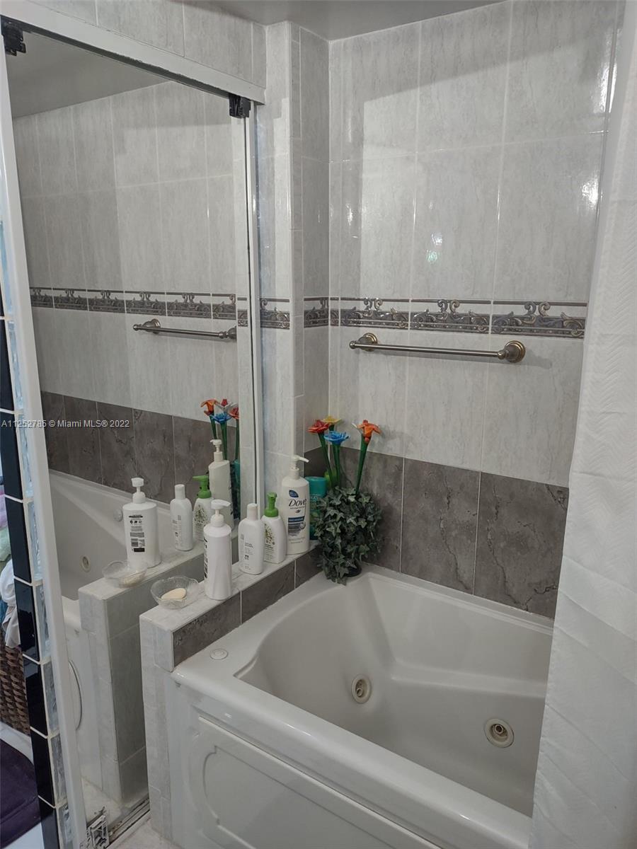 4747 Collins Avenue, Unit 107 Miami Beach, FL 33140 - Photo 11 of 15 a bathroom with a tub and sink