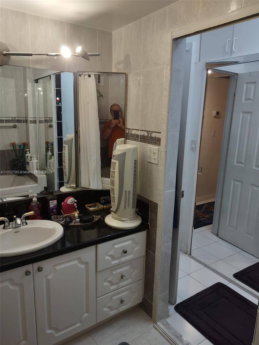 4747 Collins Avenue, Unit 107 Miami Beach, FL 33140 - Photo 12 of 15 a bathroom with double sink and a mirror