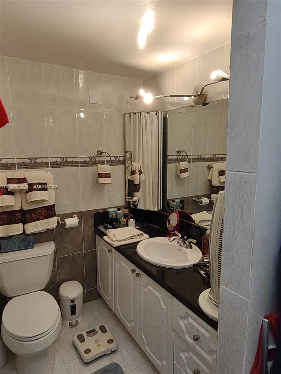 4747 Collins Avenue, Unit 107 Miami Beach, FL 33140 - Photo 13 of 15 a bathroom with a sink toilet and mirror