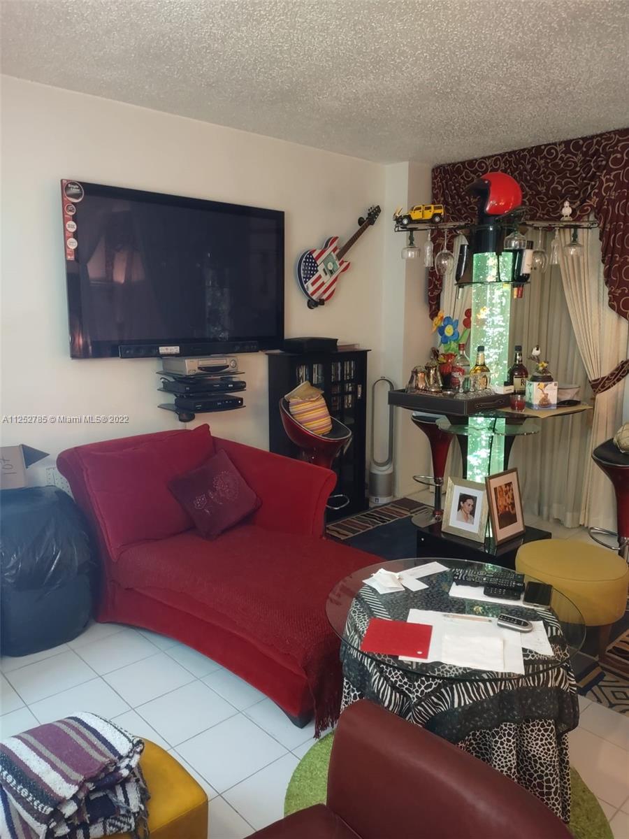 4747 Collins Avenue, Unit 107 Miami Beach, FL 33140 - Photo 8 of 15 a living room with furniture and a flat screen tv