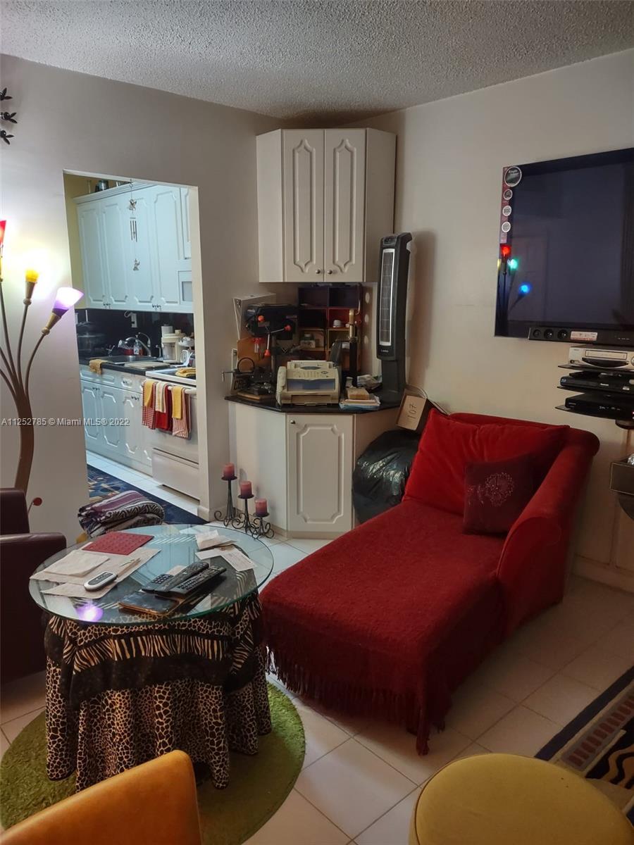 4747 Collins Avenue, Unit 107 Miami Beach, FL 33140 - Photo 10 of 15 a bedroom with furniture and a flat screen tv