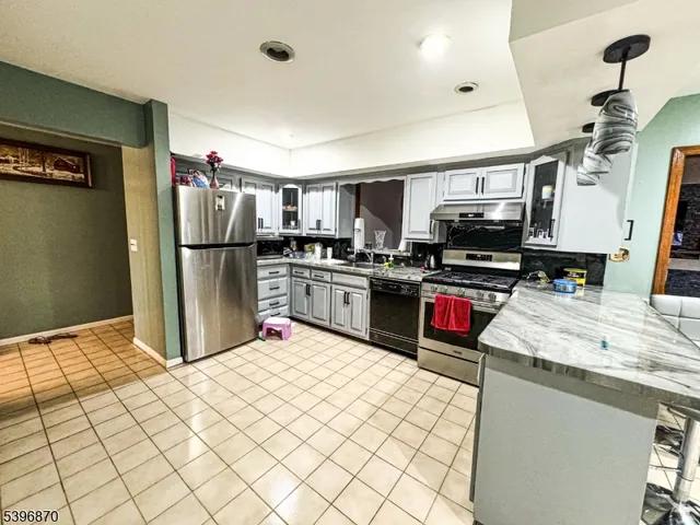 a kitchen with kitchen island a refrigerator sink and stove