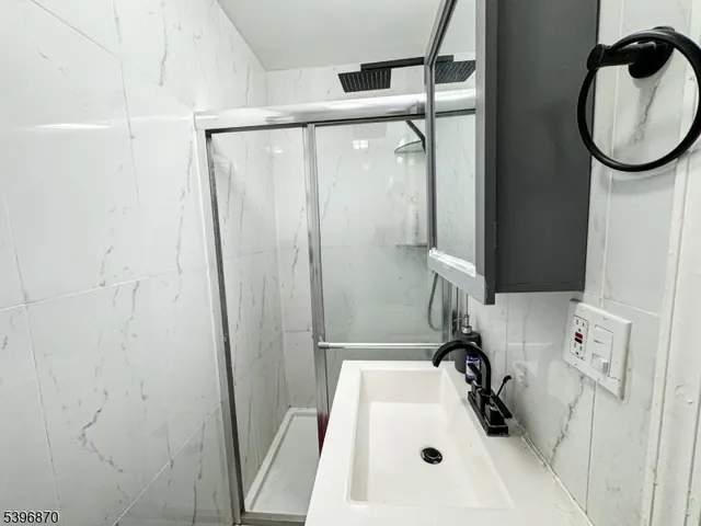 a bathroom with a sink a window and a shower