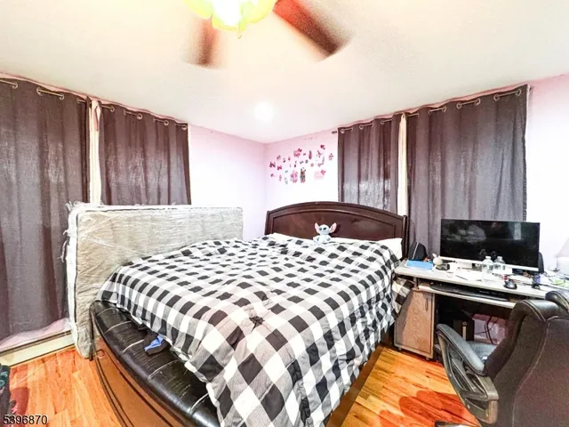 a bedroom with a bed and a lamp with wooden floor