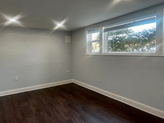 a view of a small space with wooden floor and a window