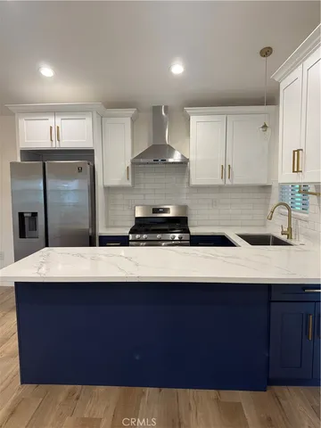 a kitchen with kitchen island granite countertop a sink cabinets and stainless steel appliances