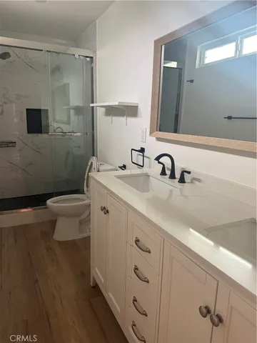a bathroom with a double vanity sink mirror and toilet
