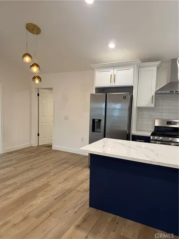 a view of kitchen with refrigerator stove and wooden cabinets