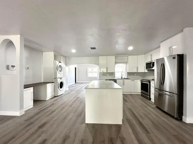 a kitchen with stainless steel appliances a refrigerator and a stove top oven