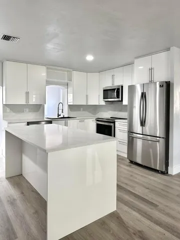 a kitchen with stainless steel appliances a refrigerator stove microwave and sink