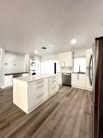 a kitchen with white cabinets and stainless steel appliances