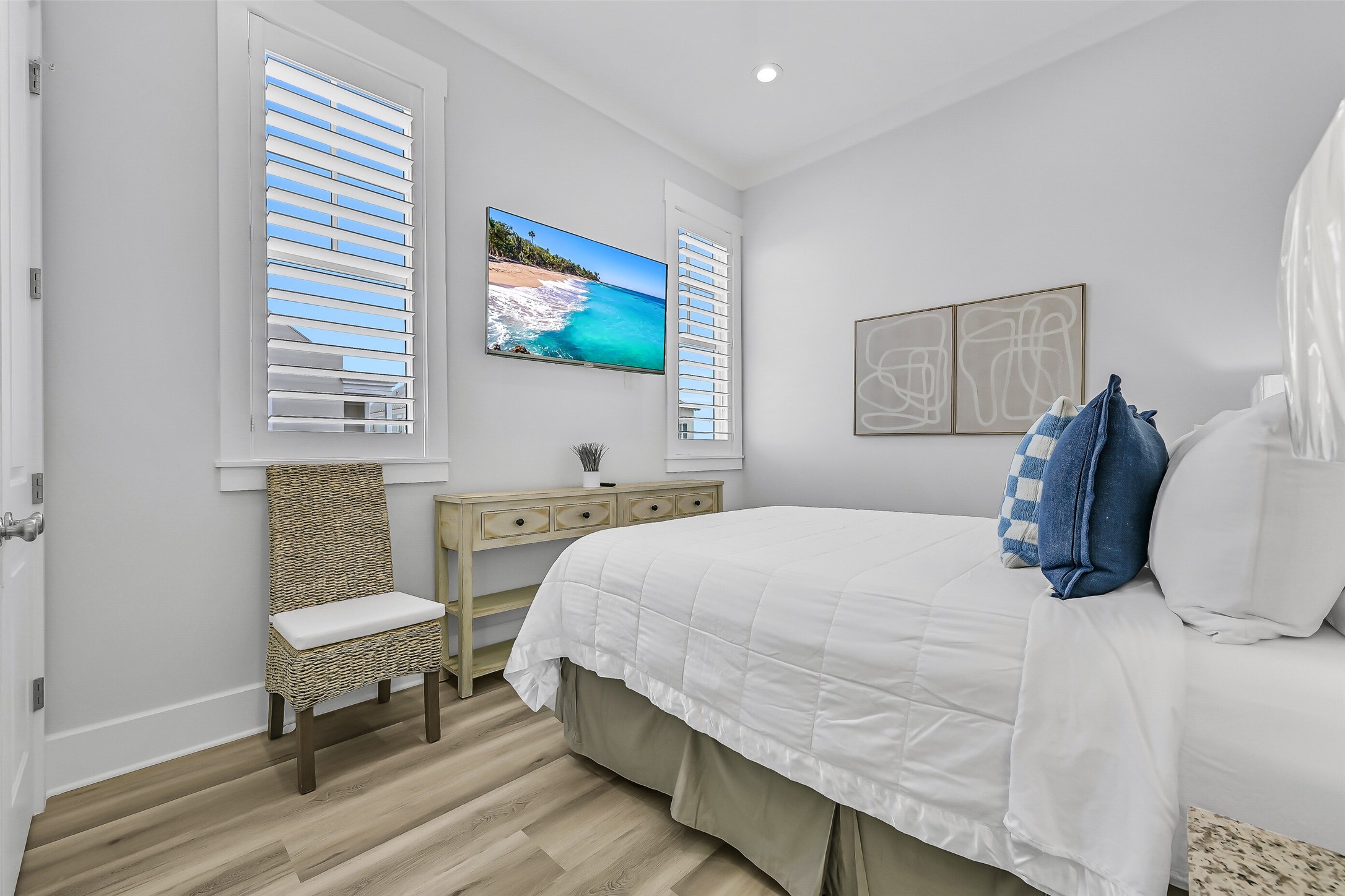 817 Positano Road Galveston, TX 77550 - Photo 26 of 50 Bright, comfortable, and thoughtfully refreshed, this secondary bedroom provides a relaxing retreat for family and guests. New beach-inspired flooring, updated furnishings, and abundant natural light create a welcoming coastal atmosphere.