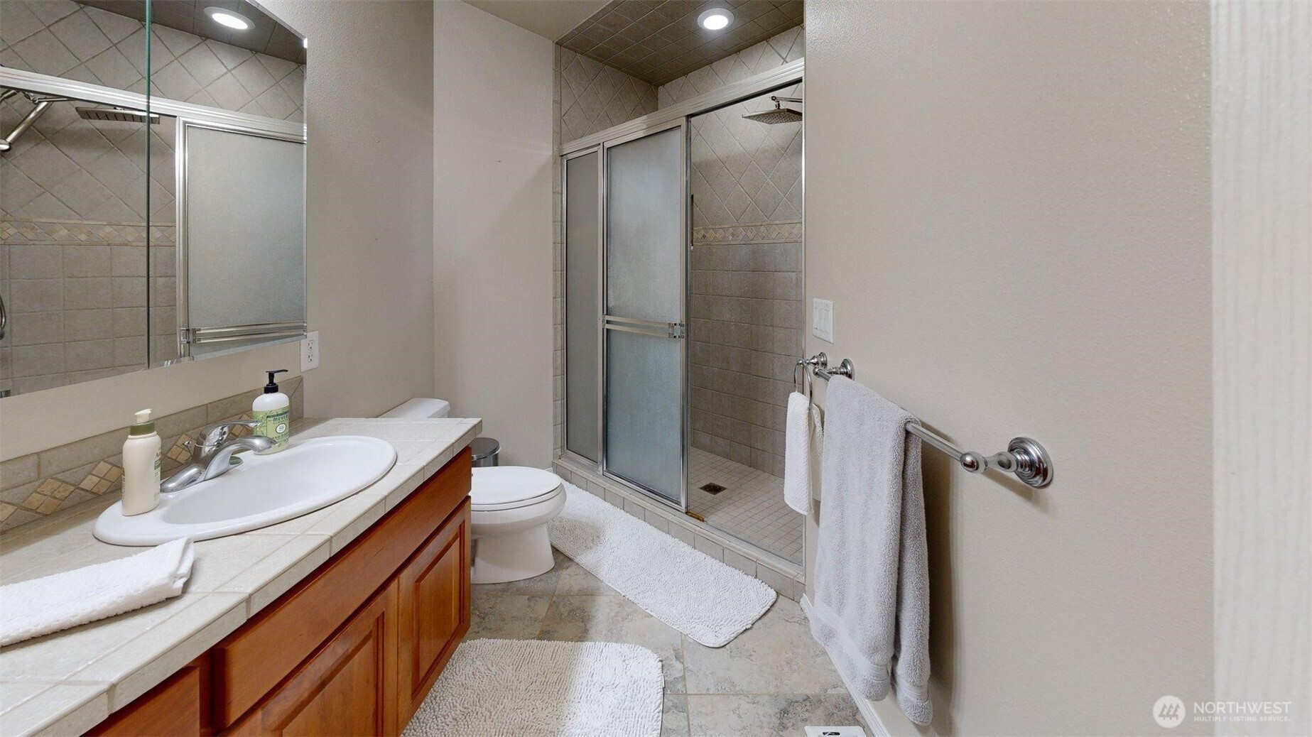 1724 Ridgeview Drive Clarkston, WA 99403 - Photo 22 of 38 a bathroom with a granite countertop sink a mirror and shower