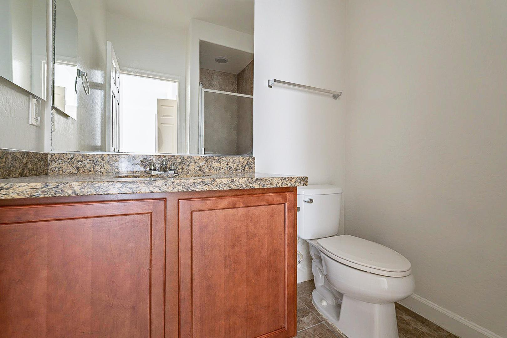 17223 North Cave Creek Road, Unit 7 Phoenix, AZ 85032 - Photo 11 of 23 a bathroom with a granite countertop sink toilet and mirror